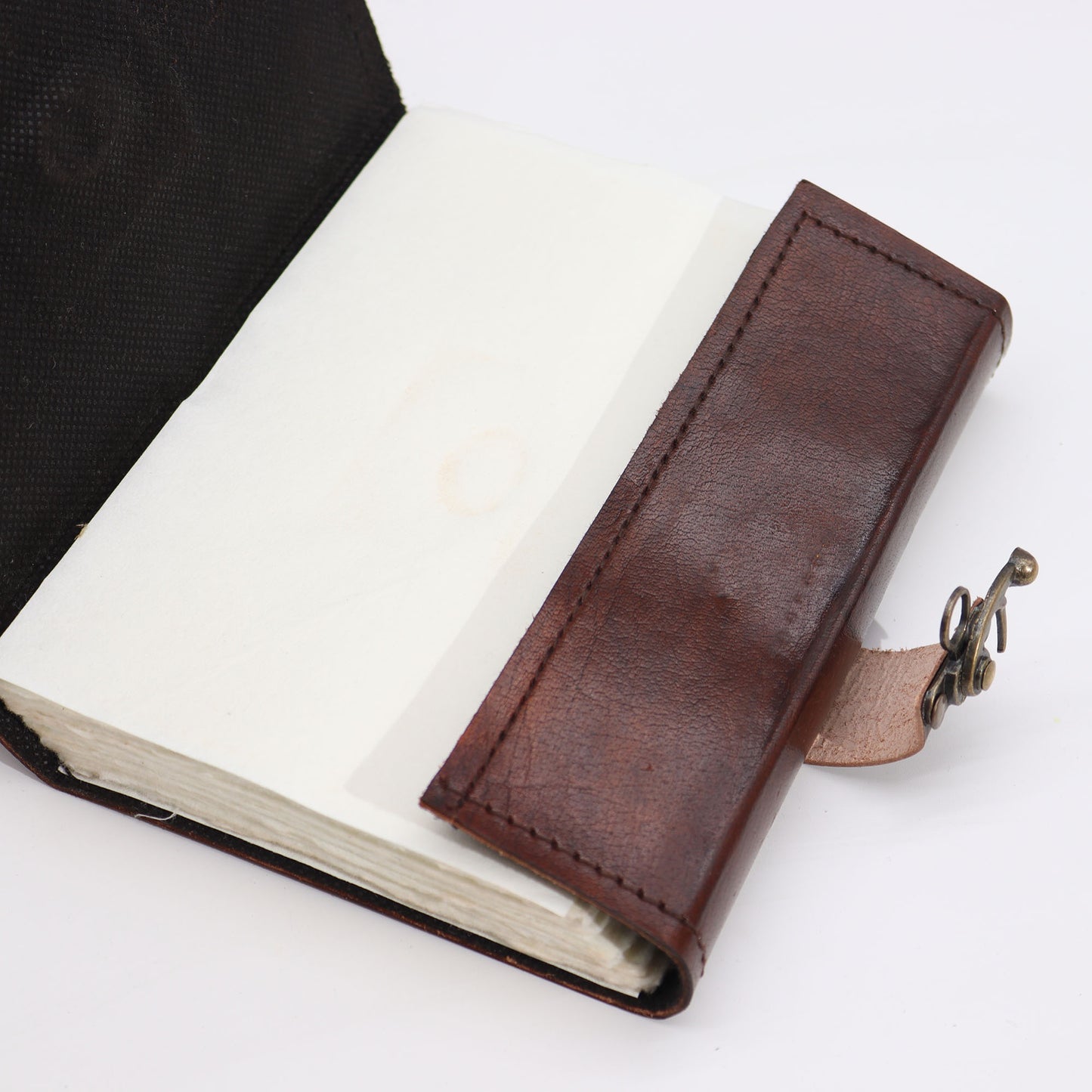 Carnet de notes marron foncé avec bords usés et motif « mauvais œil »