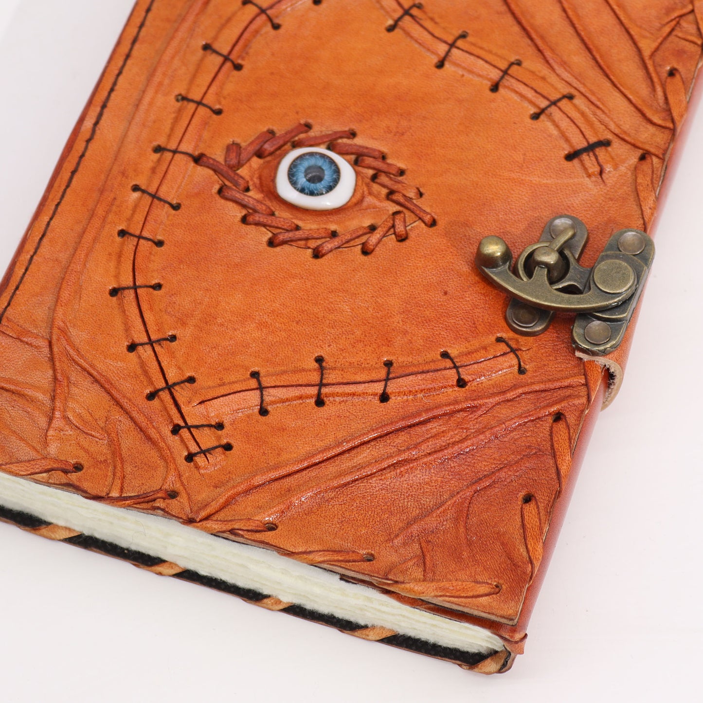 Carnet de notes marron clair avec bords usés et motif mauvais œil