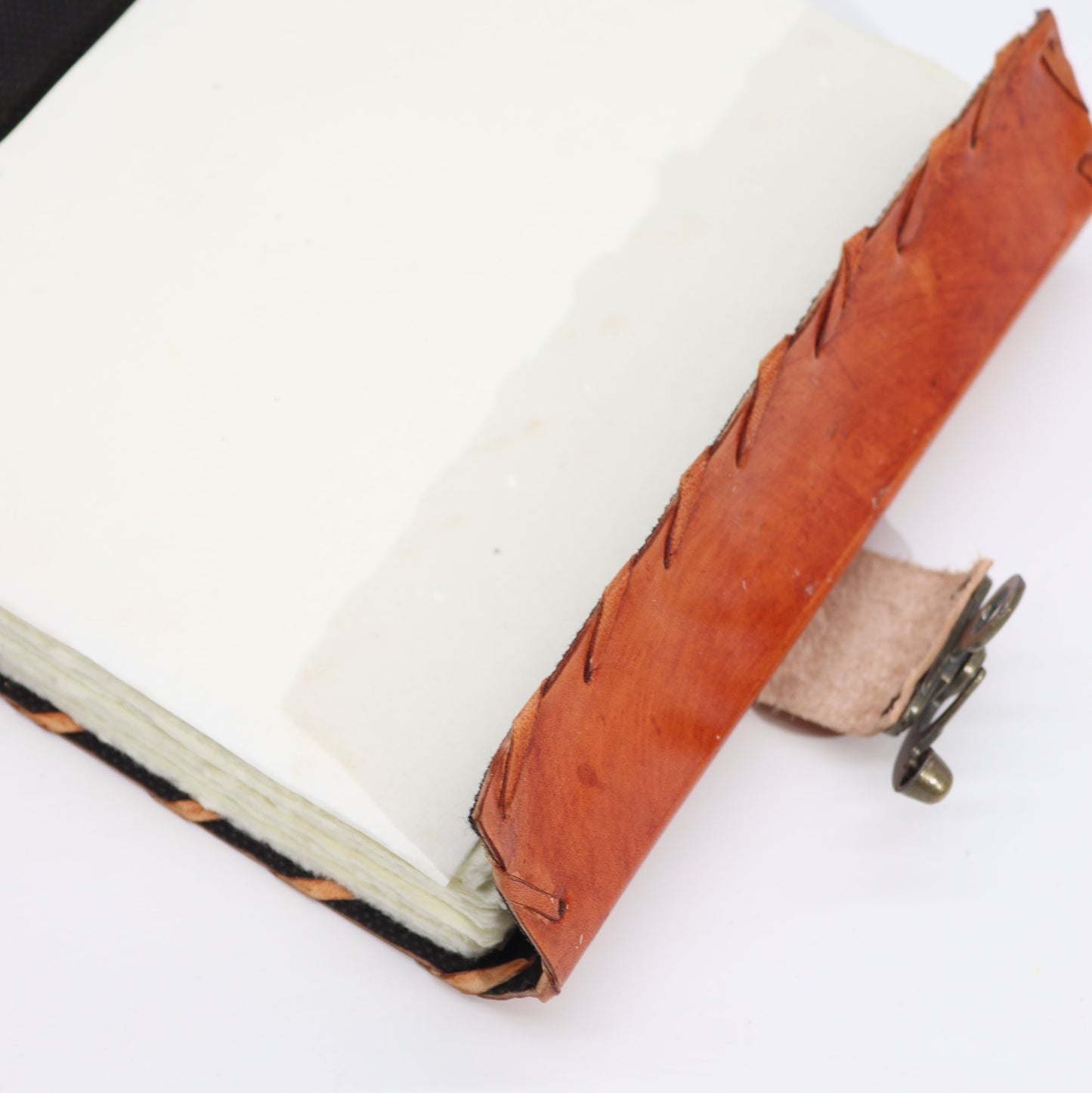 Carnet de notes marron clair avec bords usés et motif mauvais œil